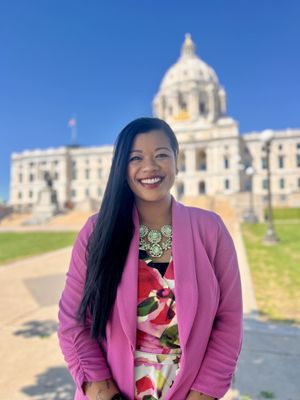 Photo of Thuba Nguyen standing in front of the Minnesota capitol building